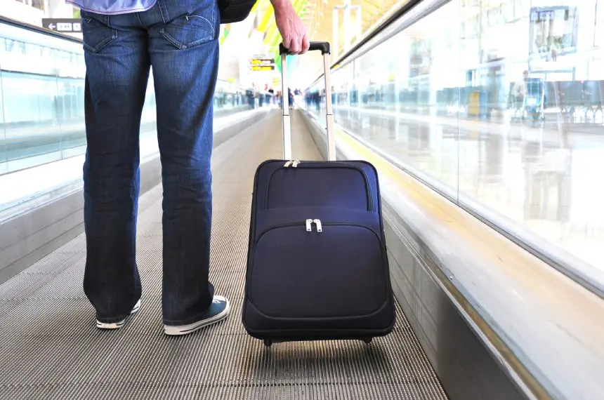A person pulling luggage on the ground.