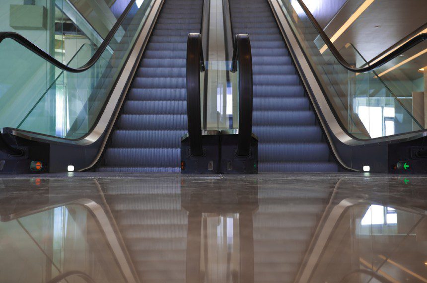 A picture of an escalator going up and down.